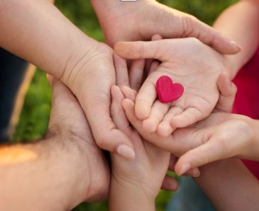 Children’s hands gathered around a small heart